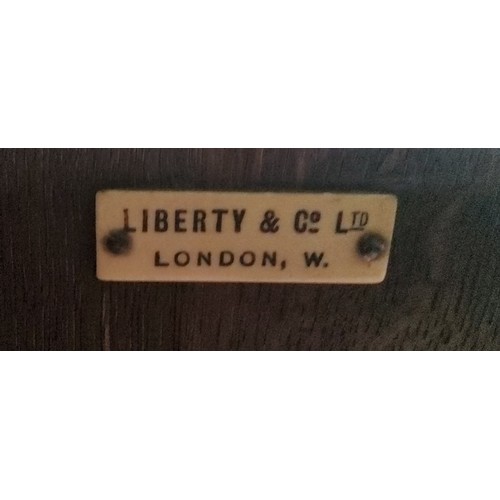 635 - Liberty & Co, London - an Arts & Crafts oak smoking room cabinet, in gilt with a lion rampan... 