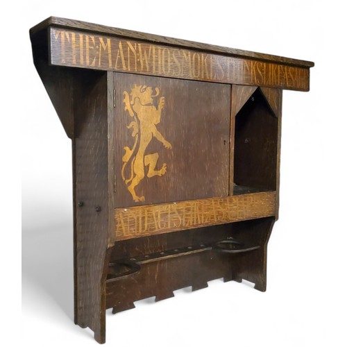 635 - Liberty & Co, London - an Arts & Crafts oak smoking room cabinet, in gilt with a lion rampan... 