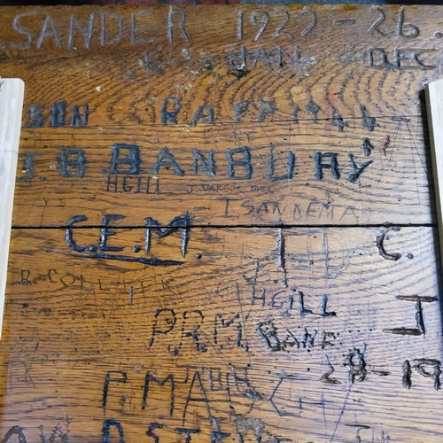 471 - An early 20th century elm and cast iron child's school desk, heavily graffitied hinged cover, 77cm x... 