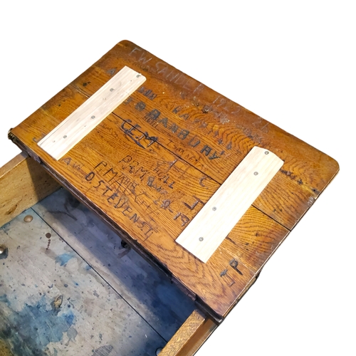 471 - An early 20th century elm and cast iron child's school desk, heavily graffitied hinged cover, 77cm x... 