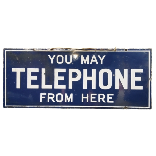 496 - An early 20th century 'You May Telephone From Here' double sided enamel sign, white lettering on blu... 