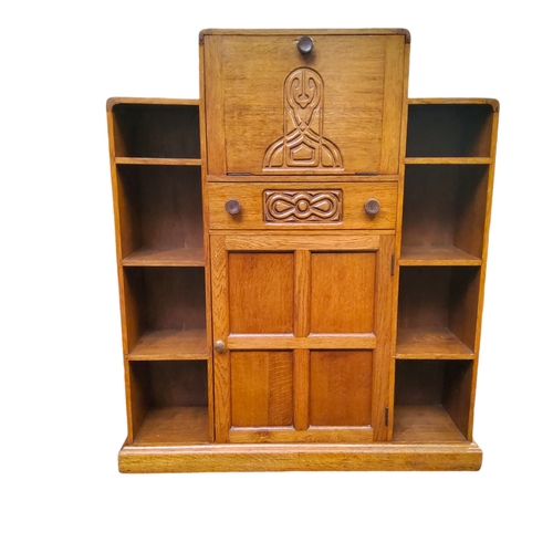 520 - An Art Deco golden oak student's bureau, the fall front carved with Celtic design revealing pigeon h... 