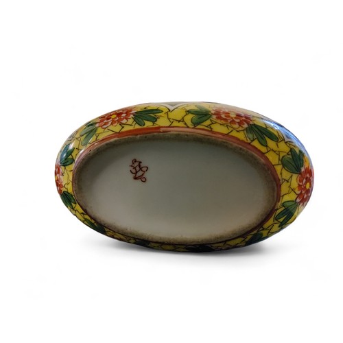 19 - A Sevres style boat shaped inkwell, with pen and seal holders,  decorated with peonies on a yel... 