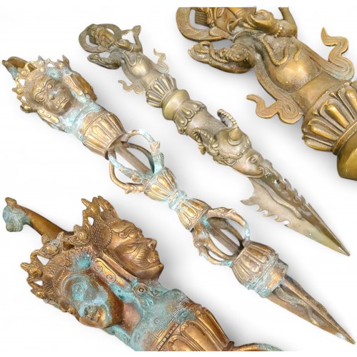 92 - Two reproduction Tibetan bronze Phurba daggers, horse head terminal above a three-headed Vishnu hand... 