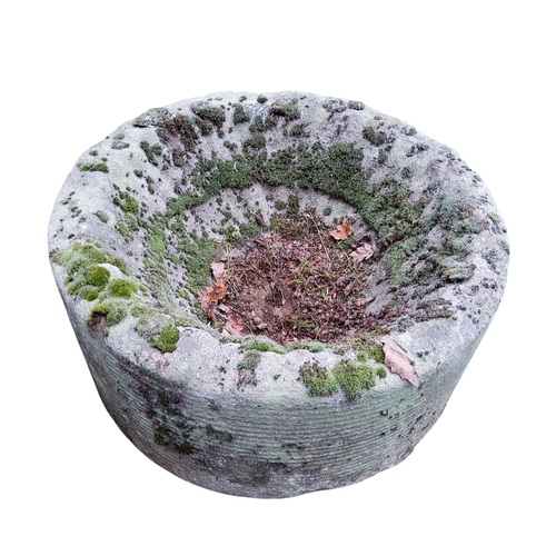 393 - A near pair of Derbyshire gritstone circular millstone type garden planters, each approximately 25cm... 