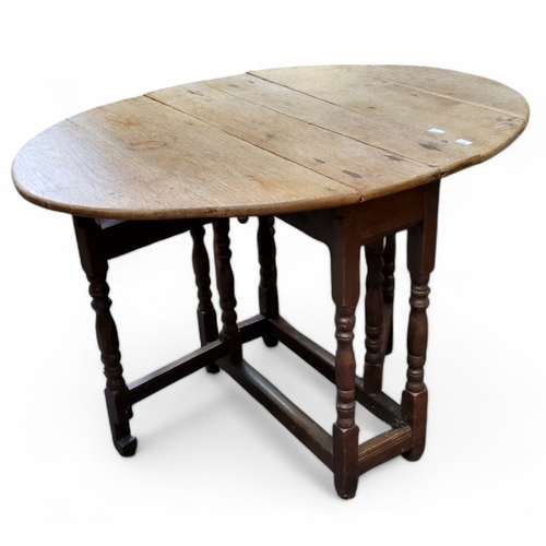 404 - A small late 18th century English oak oval drop leaf gateleg tavern table, stripped top over period ... 