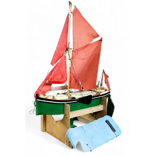 724 - A large wooden pond yacht, remote control, masts, sails and rigging, painted hull and deck, stand, n... 