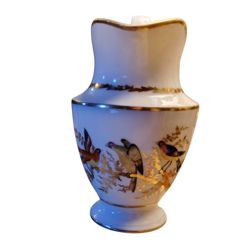 150 - An early 19th century Paris porcelain pedestal jug,  painted with fanciful birds on a gilt branch, s... 