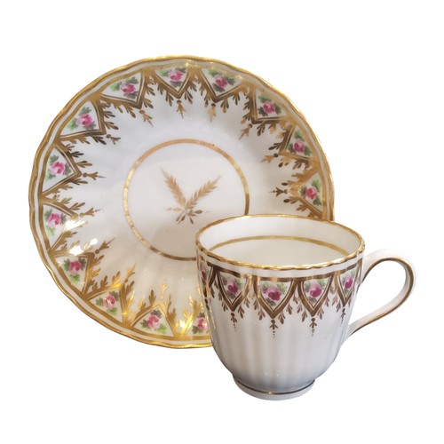 83 - A New Hall fluted coffee cup and saucer,  painted with roses in a triangular gilt panel,  pattern 83... 