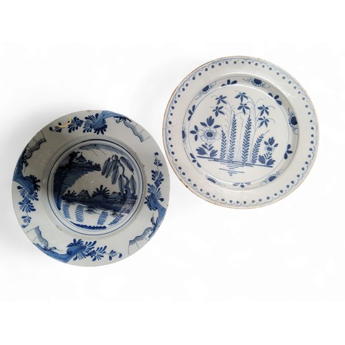 89 - An English Delft blue and white chargers, painted with stylised ferns and flowers, dot and wave bord... 