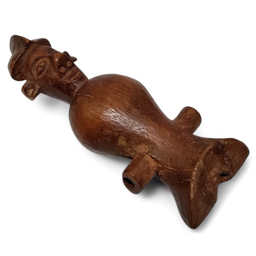 599 - Tribal Art - a novelty African hardwood whistle in the form of a male in traditional dress, 12cm