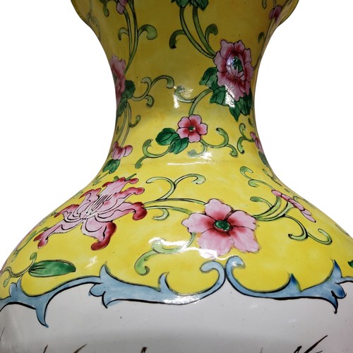 233 - A Qing dynasty Canton enamel baluster shaped vase, yellow ground, decorated with two panels depictin... 