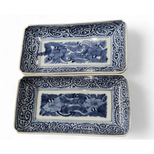 238 - A pair of Japanese rounded rectangular dishes, painted in underglazed blue with stylised lilies, dee... 