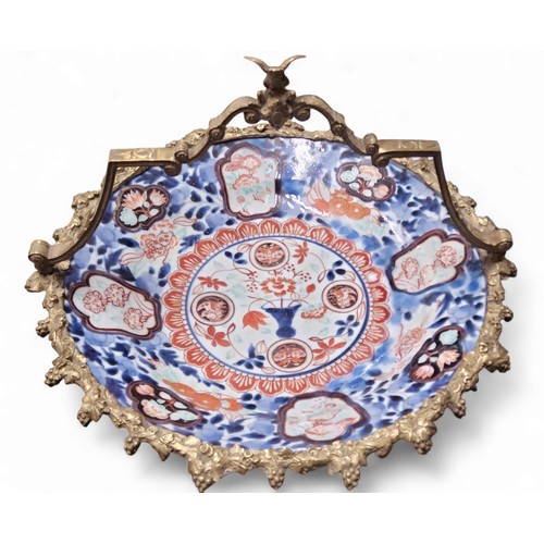 243 - A Japanese Imari and gilt metal comport, the dish decorated in the typical palette, the mounts with ... 