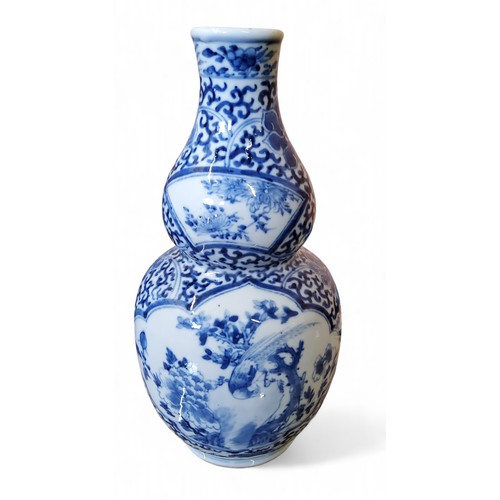 246 - A 19th century Chinese porcelain double-gourd vase, painted in underglaze blue with phoenix perched ... 