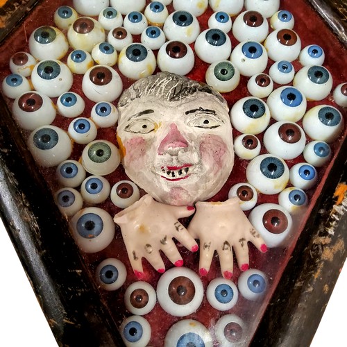 510 - Folk Art - a very unusual lozenge shaped diorama, set with a collection of prosthetic eyes surroundi... 