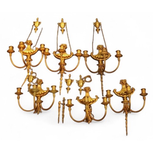 383 - A set of six gilt metal wall lights, rams' head finials, reeded arms, cm flowerhead sconces, harebel... 