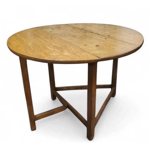 689 - A late 18th century English oak joined folding cricket table,  circular top, block stretchers, 71cm ... 