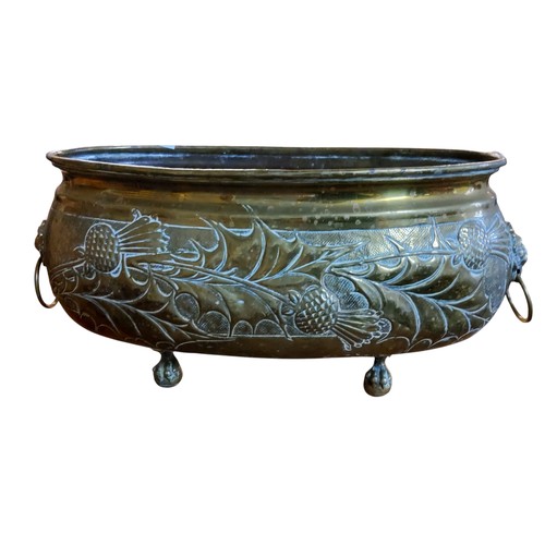 381 - A Scottish Glasgow School repousse brass oval planter, embossed with thistles, lion mask handles,  p... 