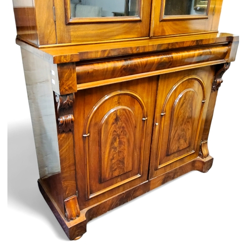 395 - A Victorian flamed mahogany bookcase, oversailing ogee cornice above cross banded arched glass doors... 