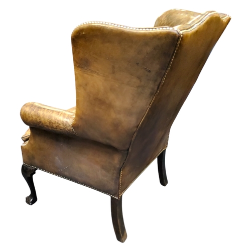 672 - A George III Revival wingback armchair, in olive green leather, cabriole forelegs terminating with b... 