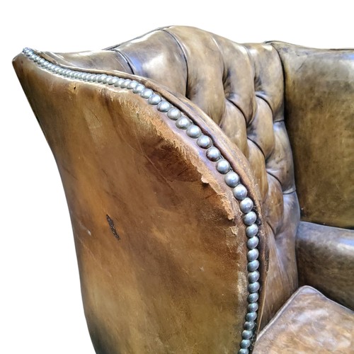 672 - A George III Revival wingback armchair, in olive green leather, cabriole forelegs terminating with b... 