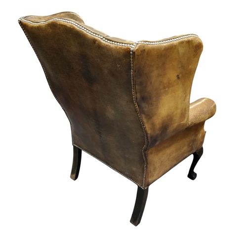 673 - A George III Revival wingback armchair,  in olive green leather, cabriole forelegs terminating with ... 