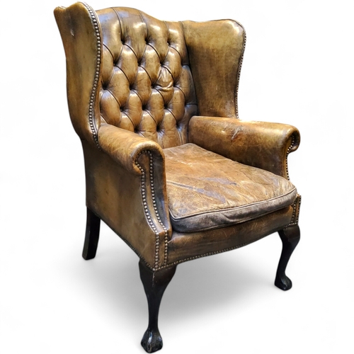 673 - A George III Revival wingback armchair,  in olive green leather, cabriole forelegs terminating with ... 