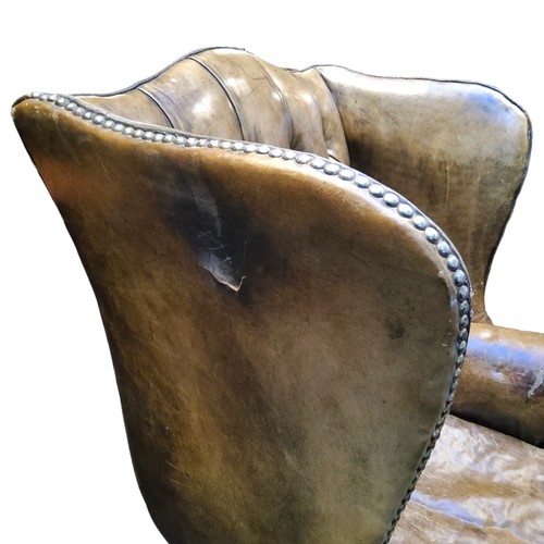 673 - A George III Revival wingback armchair,  in olive green leather, cabriole forelegs terminating with ... 