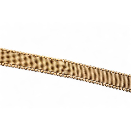 55 - A 9ct gold bracelet in the form of a belt, the mesh bracelet bordered by beads, rose gold buckle and... 