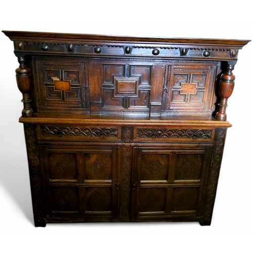 622 - An English oak court cupboard, the upper section with a dental frieze above two block fronted cupboa... 