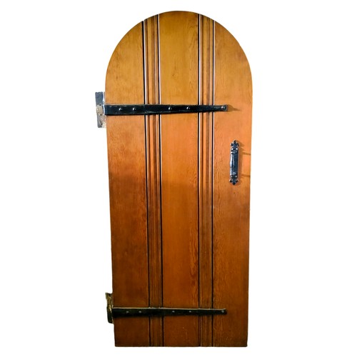 695 - Architectural Salvage - an arched pitch pine door, bold ironwork hinges, 195cm x 83cm