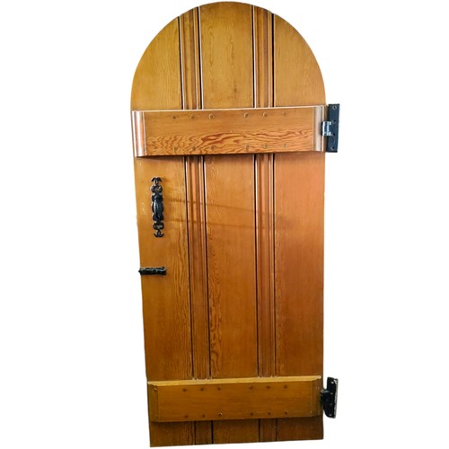 695 - Architectural Salvage - an arched pitch pine door, bold ironwork hinges, 195cm x 83cm