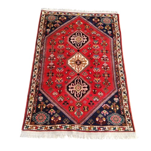 701 - An Oriental Qashgai rug, vivid tones of red and blue, three central guls, 159cm x 109cm