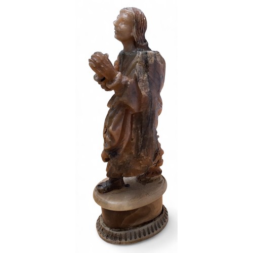 418 - An 18th century Flemish alabaster figure, of a saint praying, oval pedestal, 21.5cm high