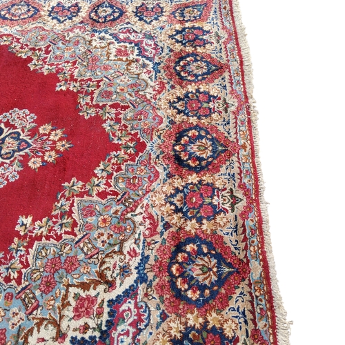 708 - An Oriental Kerman carpet, vivid tones of red and blue, 353cm x 245cm