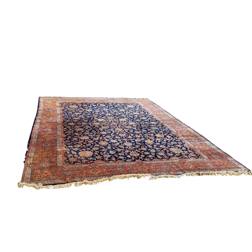 709 - A 19th century hand knotted Persian carpet, signed, in vivid tones of blue, terracotta and ivory, co... 