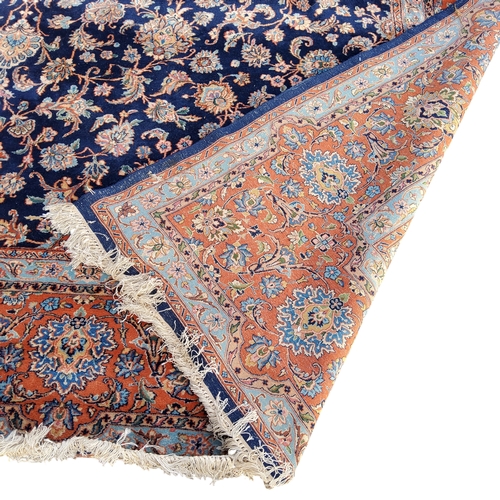 709 - A 19th century hand knotted Persian carpet, signed, in vivid tones of blue, terracotta and ivory, co... 