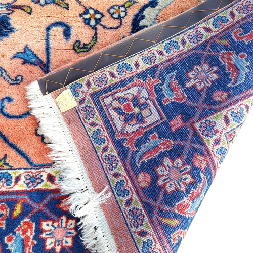 710 - An Oriental Sarouk carpet in tones of pink and blue, 266cm x 133cm