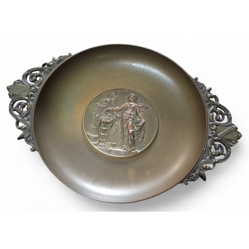 658 - A French bronzed two handled pedestal dish, the centre in relief with classical figure at a burning ... 