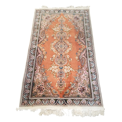 712 - An Oriental Keshan type rug with a terracotta ground, lilac and deep blue floral borders, 175cm x 10... 