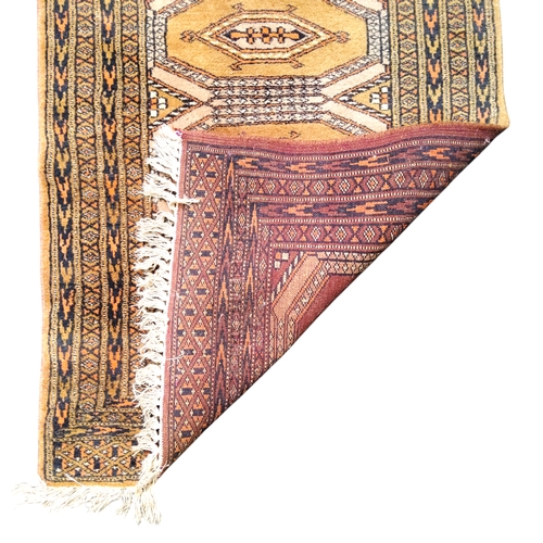 713 - A Pakistani prayer rug, four central guls on a golden ground, geometric panelled borders, 113cm x 65... 