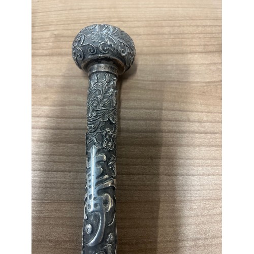 6 - A 19th century Chinese white metal parasol handle,  decorated in relief with ferocious dragons chasi... 