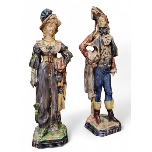 667 - Eugene Ladreyt, French 1832 - 1898, a pair of majolica figures, in 18th century dress, canted square... 