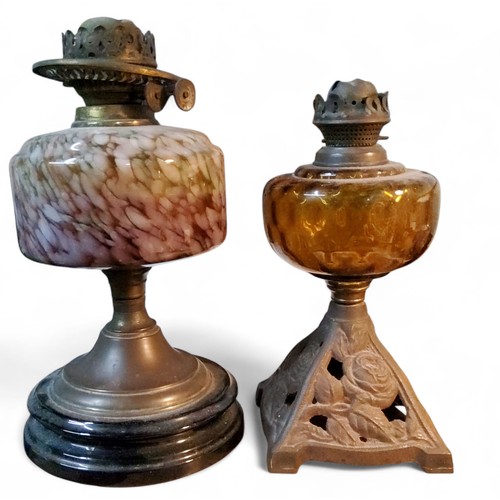 186 - An early 20th century&nbsp; oil lamp, amber reservoir, the cast iron&nbsp; pierced with roses, 28cm ... 