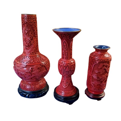79 - A Chinese red cinnabar vase, typically in relief with scrolling dragon and peonies, hardwood stand, ... 