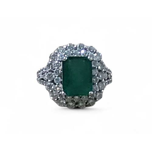 242 - An 18ct white gold, emerald and diamond ring, the central four claw set emerald cut emerald, 7.5 x 1... 
