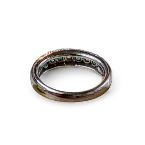 244 - A platinum and part 18ct white gold, emerald and diamond half eternity ring, channel set with four r... 