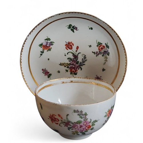 36 - A Bristol cup and saucer, decorated in polychrome with scatter sprays, gilt line border, dentil rim,... 