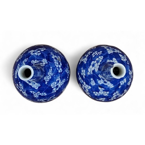 6 - A pair of Chinese bottle vases, painted in tones of underglaze blue with blossoming prunus on a&nbsp... 